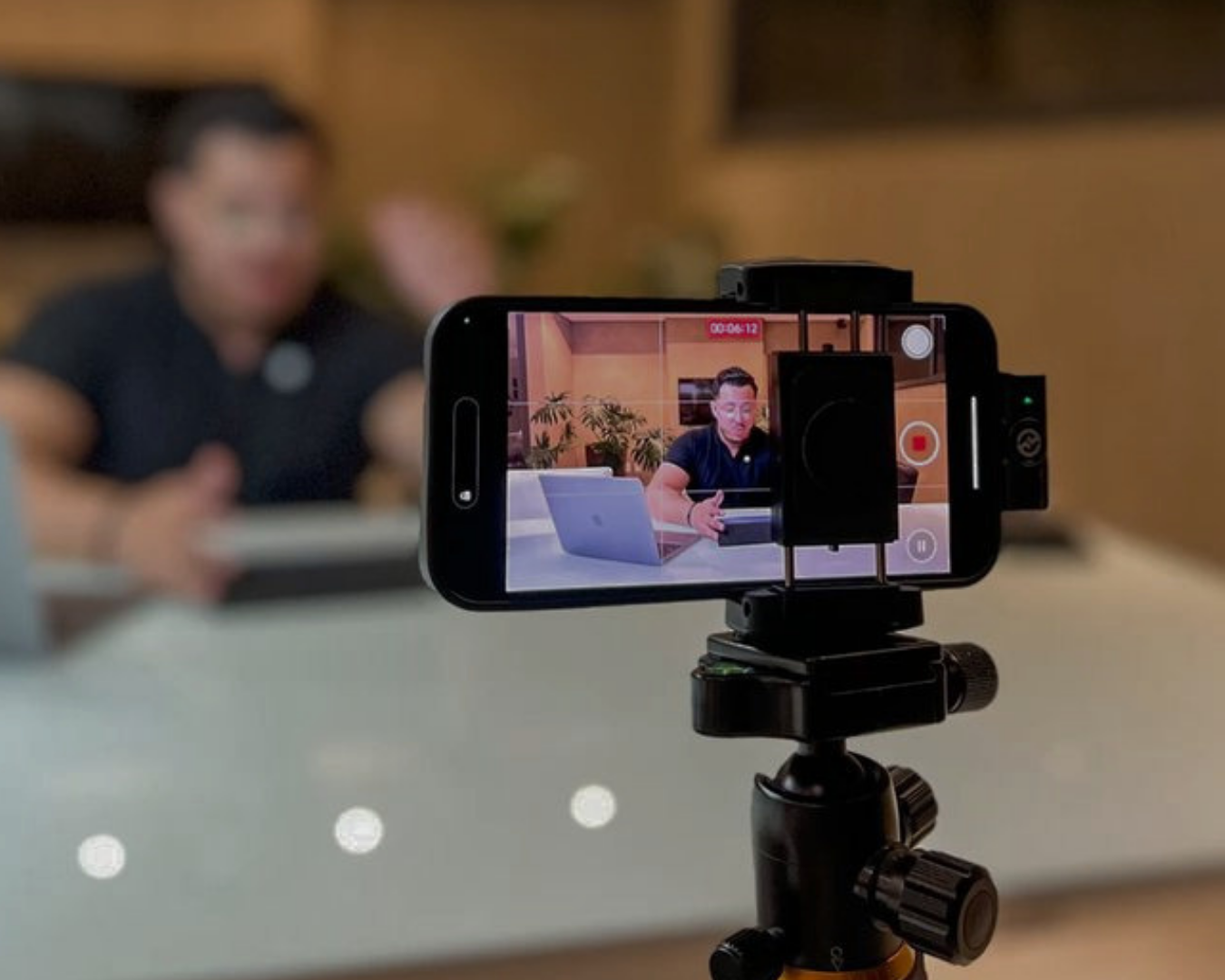 Celular em tripé gravando conteúdo com cliente ao fundo